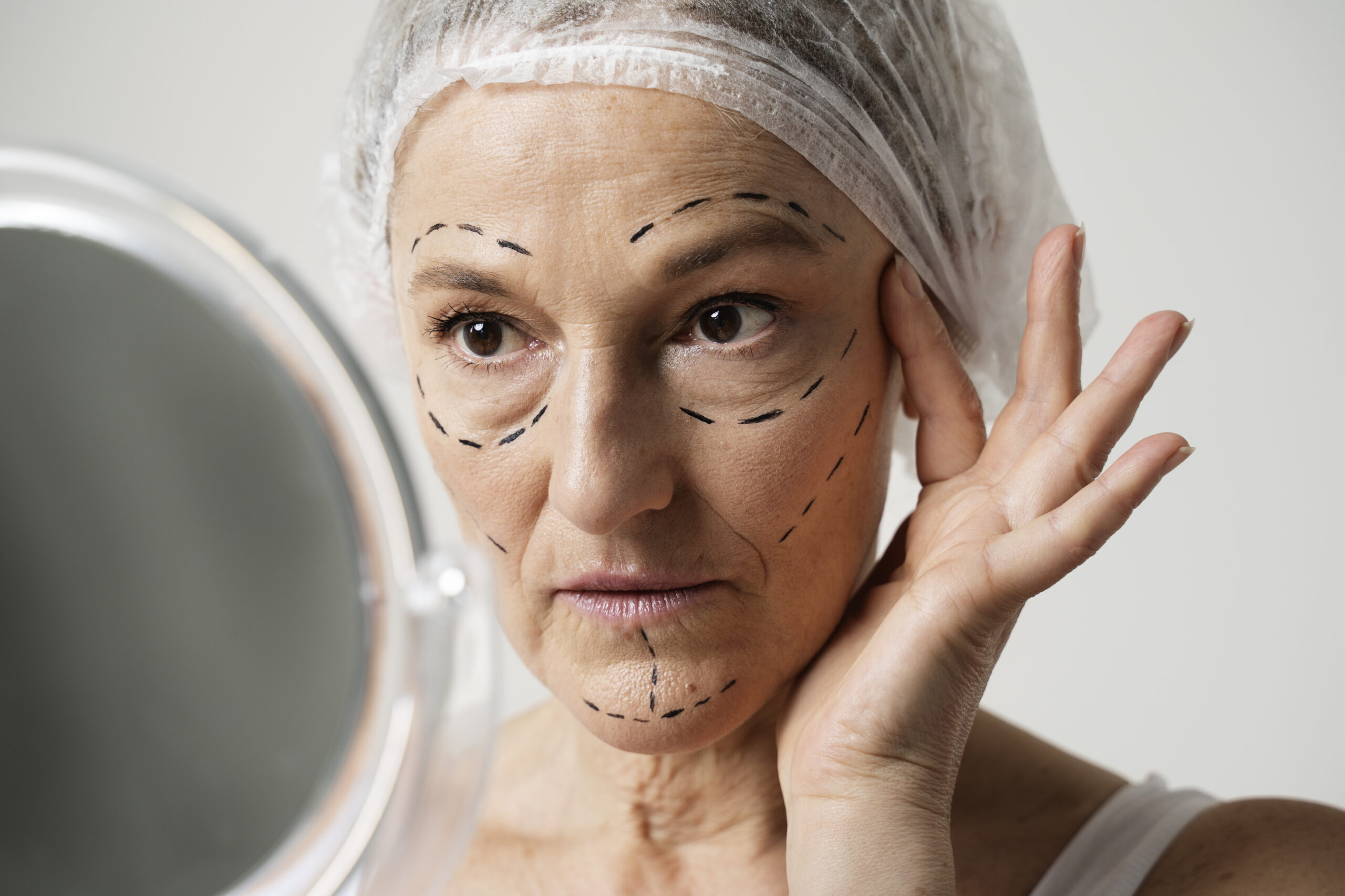woman-with-marker-traces-face-looking-mirror